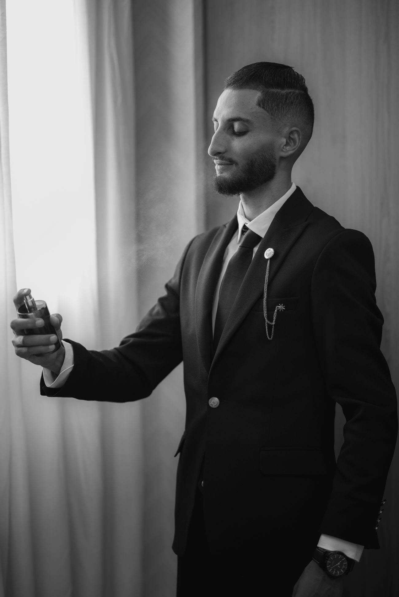Man spraying cologne while trying fragrance decants